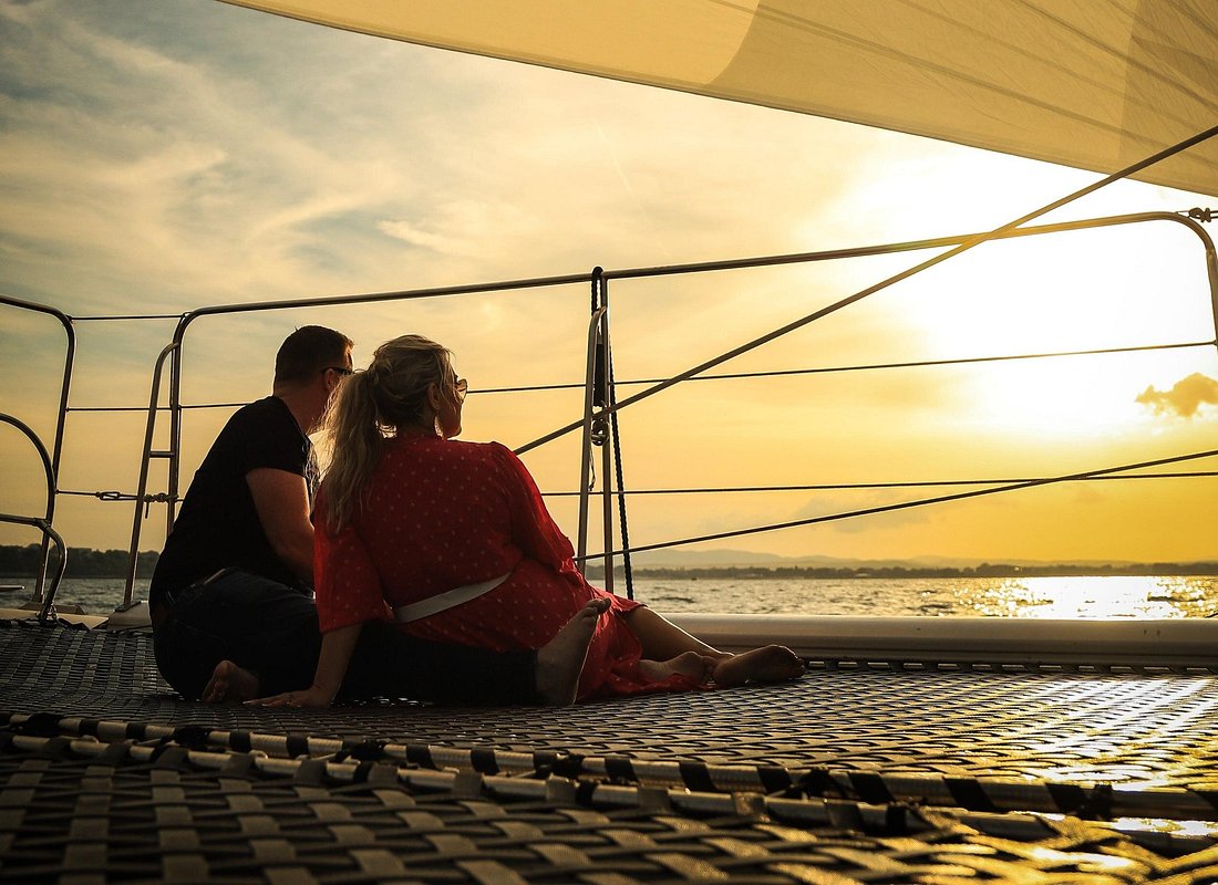 Paar auf einem Katamaran bei Sonnenuntergang, Originalbild des Anbieters